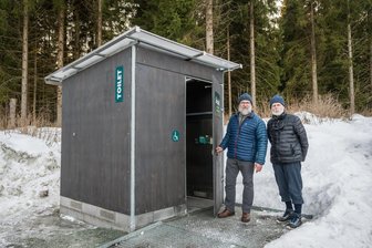 Kompost-WC an Kammloipe im Testlauf: Ort im Erzgebirge tut etwas gegen Wildpinkler - In Weitersglashütte steht am Parkplatz an der Kammloipe nun ein Kompost-WC. Die Skifahrer Jörg Flinsberger (l.) und Ehrhard Schmutzler aus Wurzen waren positiv überrascht davon.