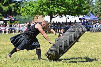 Kräftige Frauen und Männer werfen in Wechselburg den Hammer und wenden Lkw-Reifen - Der Mc Wechselbürger "Ben" Andreas Pohle beim Traktorreifen drehen. 