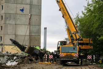 Kran hilft Bagger auf die Ketten - 