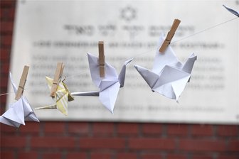 „Kraniche in Zwickau“: Was zum Holocaust-Gedenktag geplant ist - Gefaltete Papier-Kraniche vor der Gedenktafel zur Juden-Deportation am Zwickauer Georgenplatz.