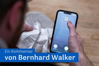 Krankschreiben per Telefon: Gut für Kinder und Eltern - Krankschreibung der Zukunft: Ein Mann hält ein Taschentuch in einer Hand und ein Telefon mit dem Schriftzug „Arzt“ in der anderen.