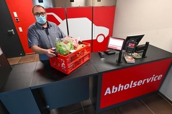 Kreative Händler in Coronaeinkaufszeiten: Es muss kein Ferrari sein - Marcel Claus, Inhaber eines REWE-Marktes, am Abholservice mit Einkäufen, die online oder per App bestellt wurden.