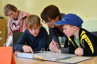 Kreativtät ist im Hort und in der Schule in Langenleuba-Oberhain hoch im Kurs - Claudia Emmerich schaut sich mit ihren Söhnen Arne und August (re.) die Schulchronik an.