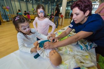  - Greta Reinhold (links) und ihre Schwester Helena lassen sich von Hebamme Romina Krauße zeigen, wie das Wickeln mit Stoffwindeln richtig funktioniert.