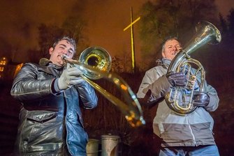 Kreuz über Schneeberg setzt Zeichen für Weihnachten - Johannes Düring (links) spielt in Schneeberg mit seinem Schwiegervater Olaf Martin Weihnachtslieder vor dem selbst gebauten Kreuz.