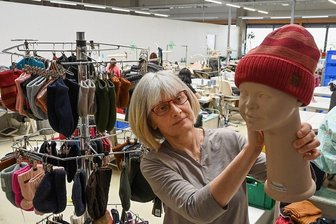 Krieg, Moral und Umsatz: Wie ein Chemnitzer Unternehmen sein Geschäft umstellt - Strickmoden Bruno Barthel produziert hochwertige Kindermützen. Katrin Meister zeigt in der Näherei ein Modell für die kommende Herbst-/Wintersaison. 
