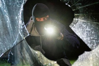Kriminalstatistik: Polizei zählt mehr Wohnungseinbrüche - Ein fiktiver Einbrecher blickt an einem Haus durch eine eingeschlagene Fensterscheibe: Die Anzahl der Einbrüche in Wohnungen im Erzgebirgskreis hat sich zuletzt spürbar erhöht. 