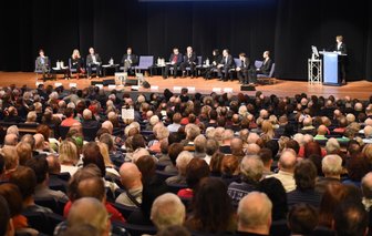 Krisenherde, Kosten, Kappel: 1200 Chemnitzer debattieren Asyl - Blick auf das von Pfarrer Stephan Brenner (5. von links) moderierte Podium auf der Bühne des Großen Saals der Stadthalle. Von links: Michael Leutert (Linke, Bundestag), Susanne Schaper (Linke, Landtag, Stadtrat), Detlef Müller (SPD, Bundestag, Stadtrat), Frank Heinrich (CDU, Bundestag), Roland Katzer (AfD, Stadtrat), Ines Saborowski-Richter (CDU, Landtag, Stadtrat), Jörg Vieweg (SPD, Landtag, Stadtrat), Thomas Lehmann (Grüne, Stadtrat), Martin Kohlmann (Pro Chemnitz, Stadtrat). Am Pult: Oberbürgermeisterin Barbara Ludwig.