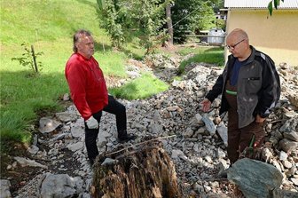 Kritik am Vogtlandkreis: Ruderitzer befürchten bei neuem Starkregen weitere Schäden - Michael Buntin (rechts) und Uwe Groh stehen inmitten der angespülten Sedimente. Nicht nur in diesem Bereich hat sich das Bett vom Ruderitzbach nach dem Starkregenereignis verändert. Beide hoffen nun auf Hilfe vom Bauhof. 