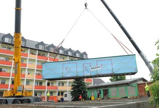 Küche schwebt sicher in den Hof - Darauf haben die 90 Bewohner und 60 Mitarbeiter lange gewartet: Dienstagvormittag wurde das erste Gebäudemodul der neuen Küche in den Innenhof des Saydaer Pflegeheims "Am Wallgraben" vorsichtig gehievt.