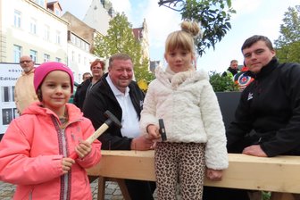 Kürbis-Zauber in Werdau: Was Besucher in Scharen auf den Marktplatz lockte - Samantha (l.) und Mila waren beim Hämmern geschickt - zur Freude von Enrico Stritzl und Bob Zesch (r.).