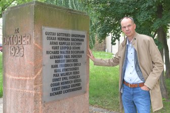 Kugelhagel an einem sonnigen Samstag: Als die Reichswehr in der Freiberger Innenstadt fast 30 Menschen erschoss - Als Freiberg Zentrum einer Protestbewegung war: Historiker Mike Schmeitzner am Denkmal der Oktoberopfer neben dem Kornhaus in Freiberg.