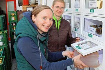 Kult-Glühwein gibt es jetzt rund um die Uhr - Doreen Bönsch (vorn) testet den Automaten. Auch Ulrike Mehlhorn ist überzeugt, dass das Angebot bei den Kunden gut ankommt.