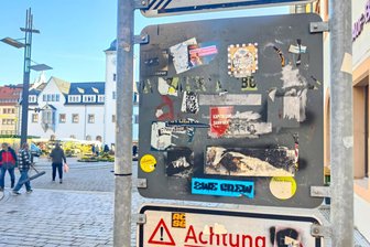 Kulturgut oder Schmutz? Das sagen Leser zu Stickern in Freiberg - Am Obermarkt in Freiberg ist ein Schild bestickert. Teilweise wurden die Aufkleber entfernt.