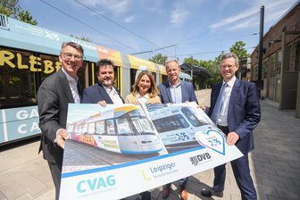 Kulturhauptstadt: Wie Dresden und Leipzig jetzt für Chemnitz werben - Straßenbahnwerbung für die Kulturhauptstadt 2025: Ulf Middelberg (LVB), Jens Maiwald (CVAG), Sybille Sonntag (Chemnitz 2025), Bürgermeister Knut Kunze und Andreas Hemmersbach (DVB) am Garagencampus und Bildern von den Straßenbahnen Leipzig und Dresden.