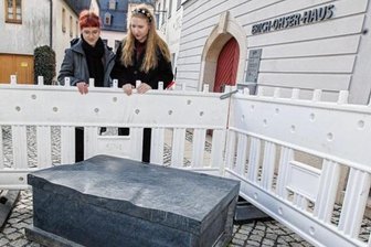 Kunstbank vor Ohser-Haus in Plauen mehrfach demoliert - Die Buchbank aus Theumaer Naturstein wurde gewaltsam von ihrem Sockel geschoben. Die Galerie-Mitarbeiterinnen Luca Wunderlich (links) und Sarah Kühnel begutachten den Schaden. 