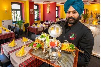 Kuppelshow, Bollywood, Tandoori: So läuft es im indischen Restaurant „Apne“ in Olbernhau - Restaurantleiter Gurpreet Singh serviert Chicken Jalfrezi.