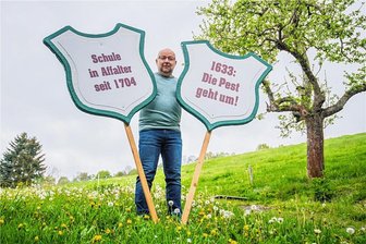 Kurios: Affalter im Erzgebirge ist heute jünger als vor 73 Jahren - Affalterer Meilensteine. Ortschronist Willi Kreutel mit zwei Schildern für den Festumzug am Samstag. Ein Großteil der Grundtafeln wurden bei der Stadt Lauter-Bernsbach ausgeborgt.