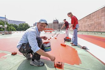 Kurios: Das Stadthallendach nimmt kunstvoll Farbe an - Künstler Larsen Bervoets wird beim Bemalen des Dachs der Stadthalle von Lina Römer, Anna Taube (von links) und anderen Chemnitzer Schülern unterstützt.