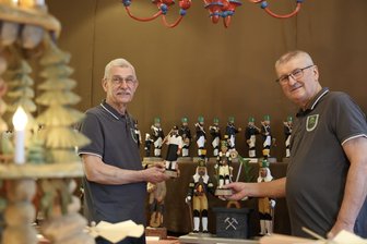 Kurios: Wieso in diesem Ort im Erzgebirge noch Schwibbögen leuchten - Rolf Herold (links) und Bernd Roscher setzen die letzten Bergmänner der Gemeinschaftsarbeit in Szene.