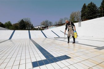Kurz vor Start der Badesaison: Waldenburg erhöht Ticketpreise - Mit einem Spezialreiniger säubert Schwimmmeister Uwe Rögner im Freibad in Waldenburg eine rund 1000 Quadratmeter große Fliesenfläche. Wahrscheinlich am Freitag beginnt das Befüllen des Beckens. 