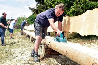 Längste Bank des Vogtlands fertig - In Gemeinschaftsarbeit ist auf dem Herrenberg in Zwota eine 30,70 Meter lange Riesenbank gebaut worden. Unter anderem gab Christian Schuster (vorn) ihr den letzten Schliff.
