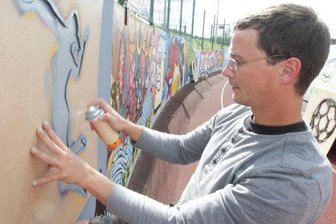 Längste Galerie im Vogtland: Plauener Graffiti-Sprayer peppen Mauer auf - André Bretschneider bei der Arbeit: Er leitet das Graffiti-Projekt auf dem Kurt-Helbig-Sportplatz.