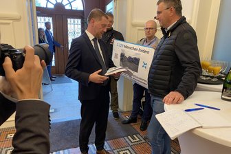 Lärm auf der B 174 und Südring in Chemnitz: Anwohner übergeben tausende Unterschriften an MP Kretschmer - Jürgen Mädler (rechts) übergibt eine Petition für Lärmschutz auf der B 174 an Michael Kretschmer.