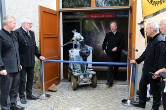 Landesausstellung: Unter-Tage-Roboter Alexander durchschneidet das Band - Freibergs OB Sven Krüger, Mittelsachsens Landrat Matthias Damm (v.l.), Oberberghauptmann a.D. Reinhard Schmidt, Erich Fritz, Vorsitzender des Fördervereins Himmelfahrt Fundgrube, und Professor Helmut Mischo (v.r.) mit Roboter Alexander bei der Schauplatzeröffnung.