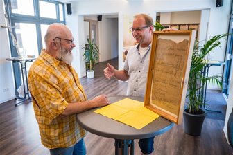 Landeskirchliche Gemeinschaft Stollberg freut sich über neue Räume: Doch wer ist das überhaupt? - Gemeinschaftsleiter Markus Schmidt (r.) und sein Stellvertreter Friedhold Scheunert im neuen Eingangsbereich. Zu sehen ist auch Fundstück von früheren Bauarbeiten, das gerahmt wurde.