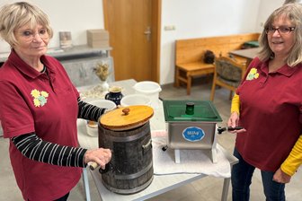 Landfrauenverein aus dem Erzgebirge stellt beim Buttern um: Warum Holz von Edelstahl abgelöst wird - Gisela Ebert (l.) mit dem alten Butterfass und Petra Schott mit dem Nachfolger aus Edelstahl.