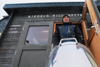 Landkreis Zwickau: Milchtankstellen bleiben Nischenangebot - Frischer kann die Milch nicht sein: Franz Riedel transportiert eine 50-Liter-Kanne vom Milchhaus auf dem Hof in den Automaten in der Hütte vor dem Hof an der Feldstraße in Cainsdorf. 