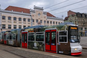 Landratsamt kippt Zwickauer Stadtratsbeschluss zu Werbeverbot für Bundeswehr – BSW kündigt juristische Prüfung an - Eine Straßenbahn mit Werbung der Bundeswehr fährt vor dem Rathaus über den Hauptmarkt von Zwickau.