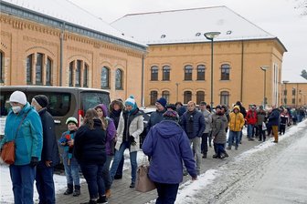 Lange Warteschlange zum Start des neuen Impfzentrums in Plauen - Bevor sich die Türen der Turnhalle im Plauener Behördenzentrum am Samstagvormittag öffneten, harrten die zur Booster-Impfung erschienenen Bürger bei winterlichen Temperaturen in der Warteschlange aus.