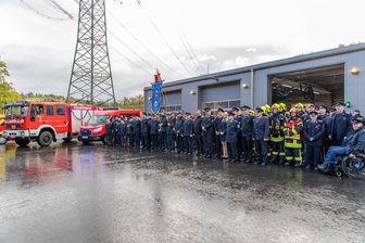 Langer Kampf und graue Haare: Feuerwehr im Erzgebirge weiht neues Depot ein - Vor der Einweihung gab es einen Marsch zum neuen Steinbacher Depot. Nach der Ankunft nahmen die Feuerwehrleute Aufstellung. Da war es noch regnerisch. Wenig später kam die Sonne raus.