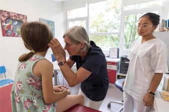 Langjährige Kinderärztin aus Freiberg: „Soziale Ängste und Essstörungen haben zugenommen“ - Auch Vorsorge gehört dazu: Kinderärztin Dr. Kathrin Schmidt untersucht Roxy. Medizinstudentin Adventina Padmyastuti (rechts), sie studiert im zehnten Semester in Greifswald, absolviert derzeit einen Teil ihrer Famulatur in der Freiberger Praxis.