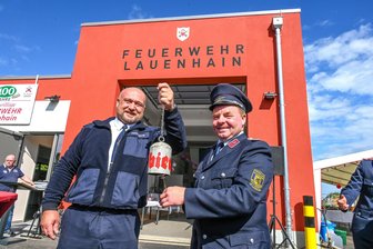 Lauenhain: Neues Gerätehaus als Geschenk zum 100. Feuerwehr-Geburtstag - Geschenk von René Golsch (l.) von der Feuerwehr Burgstädt: Eine Glocke, hergestellt aus einer Druckluftflasche. Wehrleiter Henry Schöne aus Lauenhain freut sich.