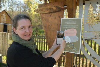 Laufen und Lauschen im Wildbacher Sagenwald - Annett Beier an der Station "Die Alte Frau in der Isenburg" vorm Backhaus in Wildbach.