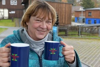 Lebendiger Adventskalender erlebt Premiere in Mulda - Noch eine Premiere: Organisatorin Petra Schumann präsentiert die ersten Glühweintassen des Gewerbevereins Mulda, hier vor der Brettmühle. 