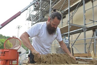 Lehm, Stroh, Holz: Im Rittergut Bösenbrunn bauen Rodersdorfer Handwerker wie vor 300 Jahren - Daniel Meinel, Chef der Firma Meinel Holz aus Rodersdorf, bereitet Lehmwickel vor.