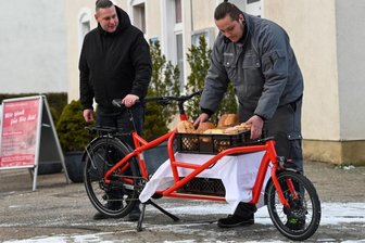 Lehrlinge erledigen Einkäufe künftig mit einem Lastenfahrrad - Auszubildender Felix Kunze (rechts) bestückt das elektrische Lastenfahrrad mit Brot, Brötchen und Kuchen. Vom Eckladen an der Schulstraße in Hartmannsdorf aus werden die Waren ausgeliefert. Ausbilder Daniel Tischer steht Kunze zur Seite.