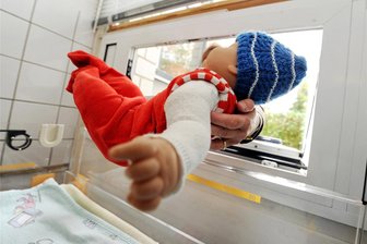Leibliche Eltern gesucht: Wer hat ein Kind in die Chemnitzer Babyklappe gelegt? - Eine Puppe wird in eine Babyklappe gelegt. Das Bild stammt aus Karlsruhe. In Chemnitz bittet das Klinikum, keine Fotos des „Babykorbs“ aufzunehmen. Man möchte keine Werbung dafür machen.