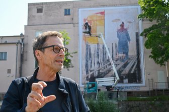 Leichtfüßige Kunst am Luxor: Das hat es mit dem großen Poster auf sich - Der Chemnitzer Künstler Steffen Volmer war am Morgen des 3. Juni dabei, als sein 130 Quadratmeter großes Kunstwerk am Luxor gegenüber der Hartmannfabrik aufgehängt wurde.