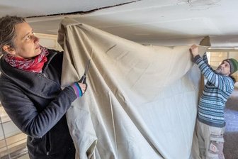 Leinen und Gold lassen Kirche leuchten - Die Restauratoren Sandra Finsterbusch und Jens Wirth erneuern die Leinwand-Papier-Bespannung der Emporen in der Stadtkirche Treuen.