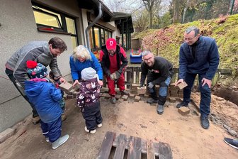Lengenfeld: Mit 50.000 Euro Spenden entsteht ein neuer Krippengarten - David Böttger, Anett Nagel, Helge Fuchs, Max Jahn, Olaf Schwarzenberger und die Kinder Minna, Luna und Matilda gehörten zum Team, das am Donnerstag die alten Pflastersteine an der Kita „Am Park" in Lengenfeld entfernte.