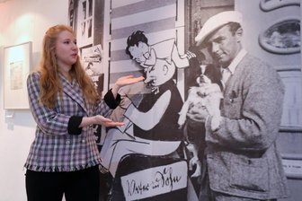 Lesung zu Ehren Erich Kästners in der Galerie e.o.plauen - Interimsgaleristin Sarah Kühnel im Erich-Ohser-Haus vor der Fotowand mit einem Abbild von Erich Kästner.