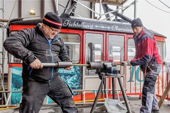 Letzte Vorbereitungen: Region am Fichtelberg steht vor Start in die Sommersaison - René Lötzsch (links), Geschäftsführer der Fichtelberg Schwebebahn GmbH, und Peter Weiß, selbstständiger Seiler mit Fachrichtung Seilbahnseilerei aus Flinsbach am Inn, bei Revisionsarbeiten an der Schwebebahn. 