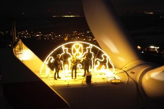 Licht Aus am Windrad-Schwibbogen in Mülsen: Wo Windkraftfreunde und Gegner zusammenkommen - Hoch oben auf dem Windrad bliesen Daniel Lauer und Robert Häcker zum Feierabend.