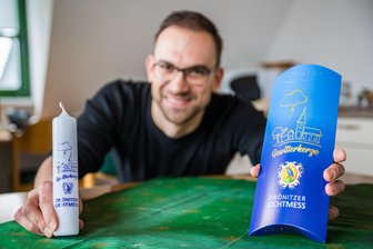 Licht aus, Gewitterkerze an: Wie die Zwönitzer zu Lichtmess einen Aberglauben ins Erzgebirge holen - Die Gewitterkerze zur Lichtmess 2025: Lila Schrift, hübsche Geschenkverpackung. Im Bild ist Martin Ahlheim, Mitarbeiter im Bürgerservice der Stadt Zwönitz.