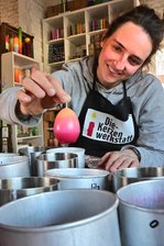 Licht und Leben: Die Osterkerze findet ihren Weg aus Kirchen und Gotteshäusern in die heimischen vier Wände - Erst gelb, dann rosa und rot – Luisa Koß zeigt im Workshop, wie die Kerze „gefühlvoll“ getaucht wird. Mit speziellen Wachsmalstiften erhalten die Selbstgemachten den letzten Schliff (unten). Bunt ist das Angebot passender Kerzen zum Osterfest in der Dresdner Werkstatt (oben). So dagegen sehen die anspruchsvollen Arbeiten von Elisabeth Preis aus, die kirchliche Osterkerzen mit Ikonen von Hand bemalt (Mitte).
